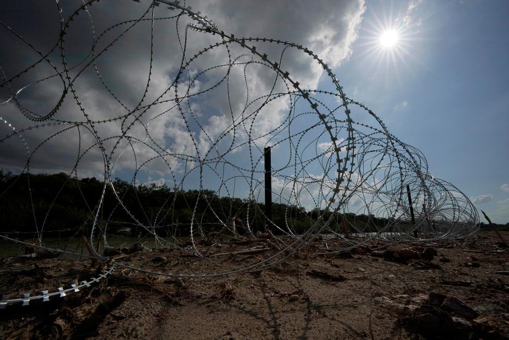 Concertina wire lines the banks of the Rio Grande on the Pecan farm of Hugo and Magali Urbina, near Eagle Pass, Texas