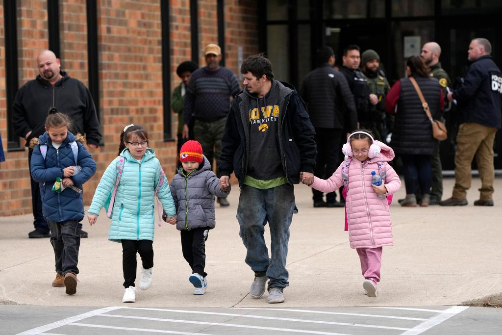 Dad and children leave the McCreary Community Building after being reunited following a shooting at Perry High School