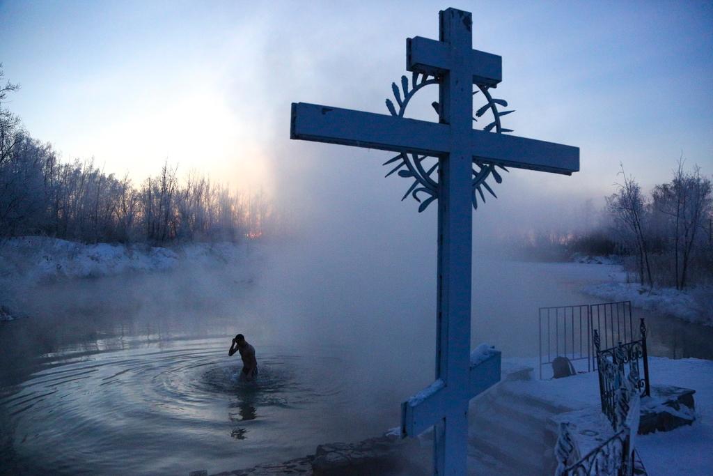 A man crosses himself while bathing in the water during a traditional Epiphany celebration as the temperature dropped to about -24 degrees near the Achairsky monastery 