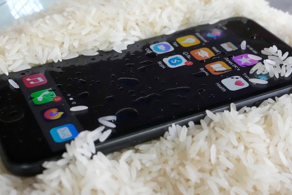 A view of a wet smartphone placed in a bowl of rice to dry