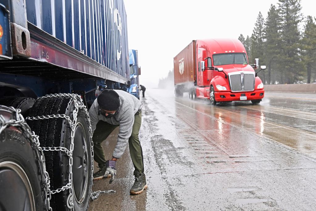 Mangal Singh parks his truck off the I-80 to put chains on his truck wheels in preparation for the snow storm over the Sierra Nevada 