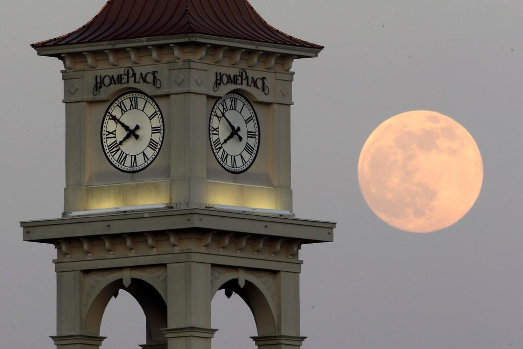 The moon rises behind the Home Place clock tower in Prattville, Alabama