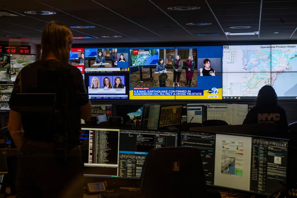 People monitor media reports at command center of the New York City Emergency Management Department 