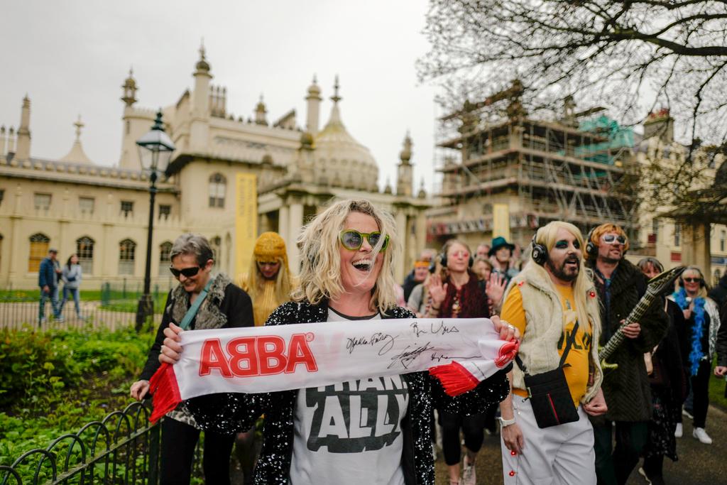 Woman holds an ABBA scarf, during a silent disco event outside the Brighton Dome, in Brighton, England