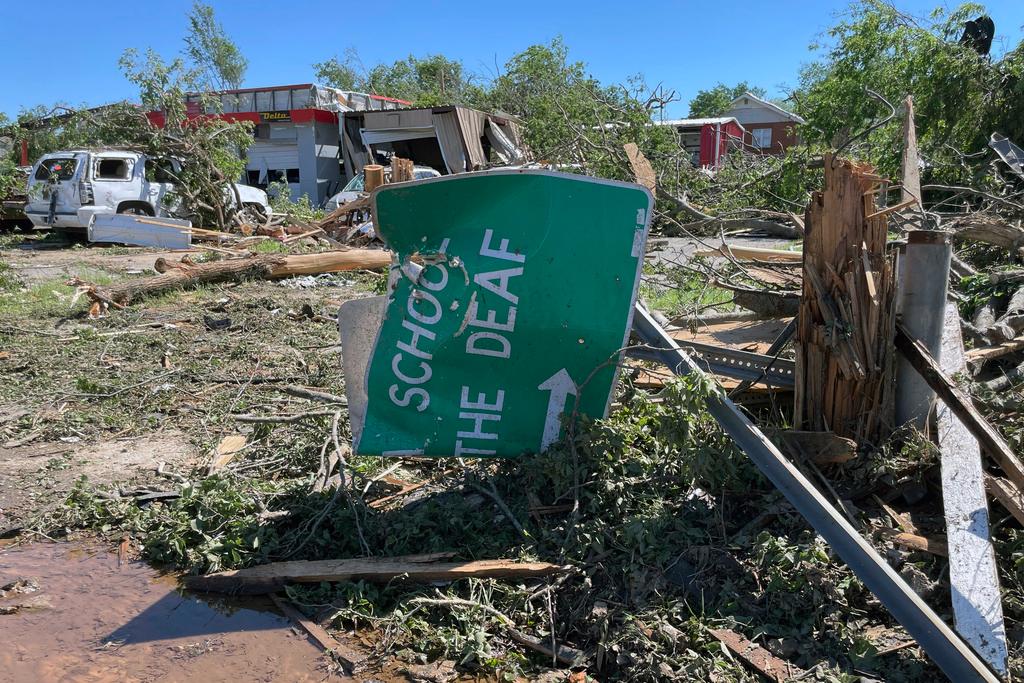 A sign for the Oklahoma School for the Deaf, lies crumpled and twisted near downtown Sulphur, Oklahoma