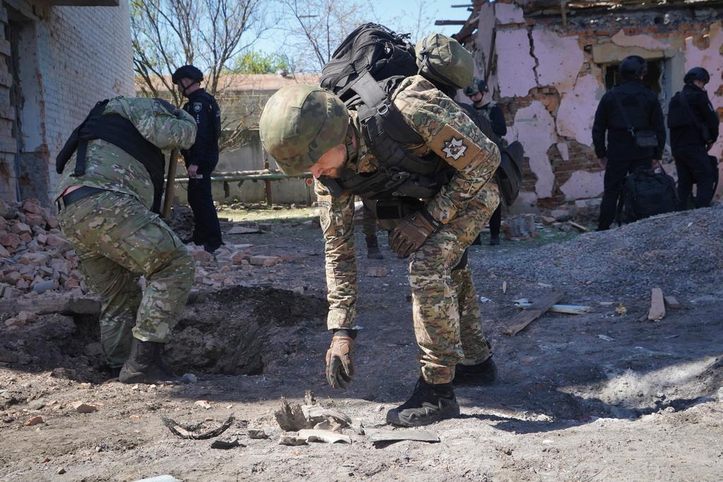 A police officer examines fragments of a guided bomb after the Russian air raid in Kharkiv, Ukraine