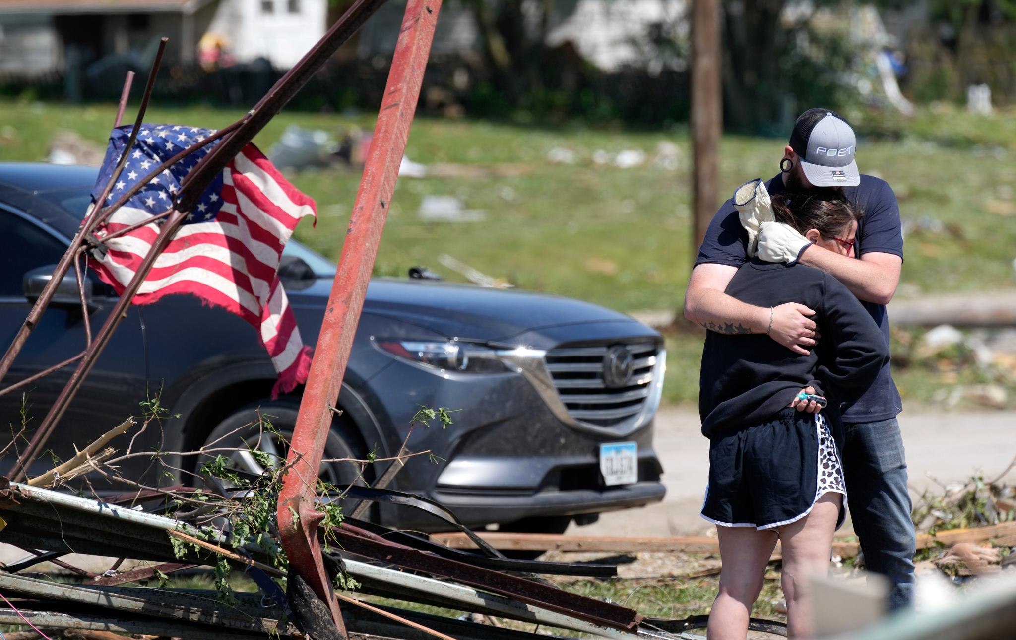 Man hugging woman near rubble after tornado
