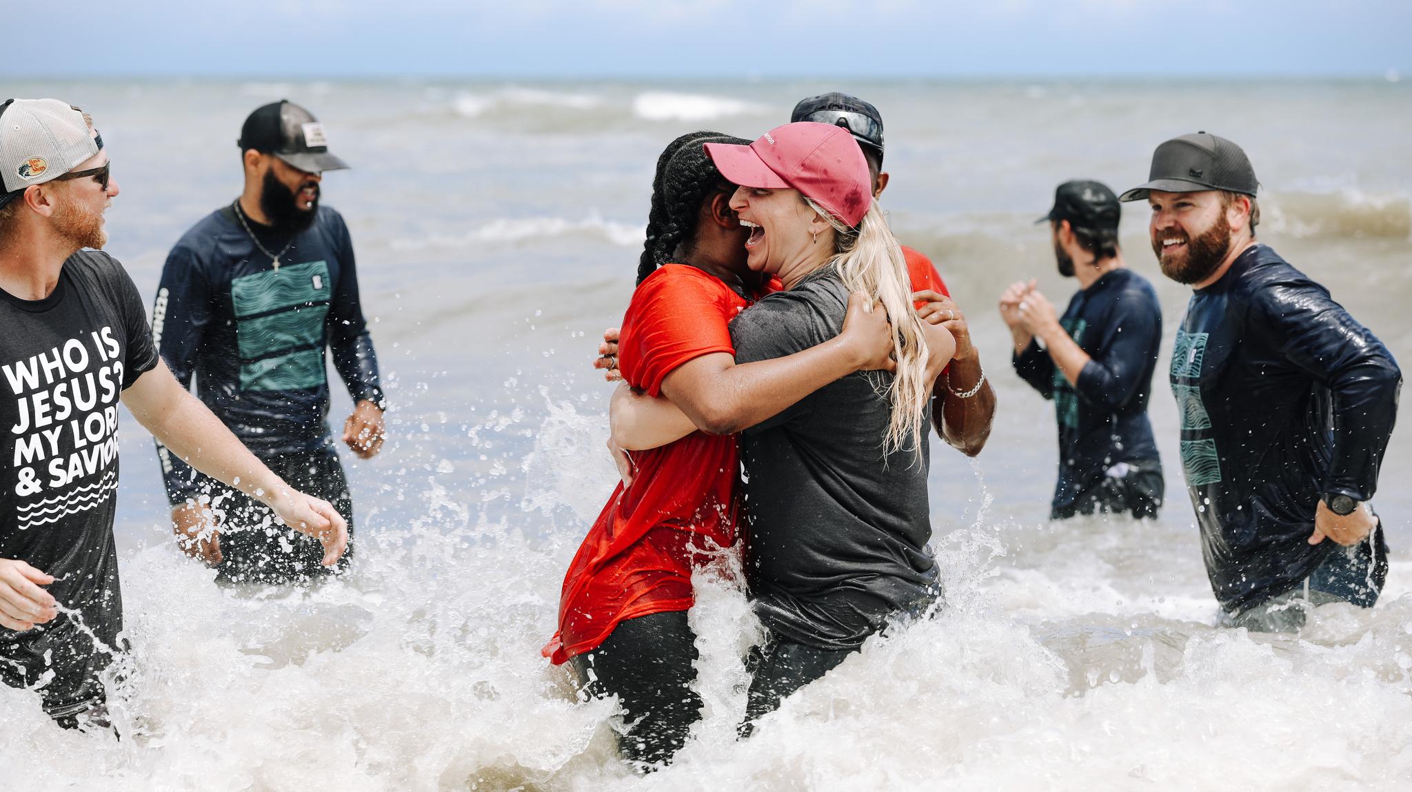 Women hugging with joy in the ocean