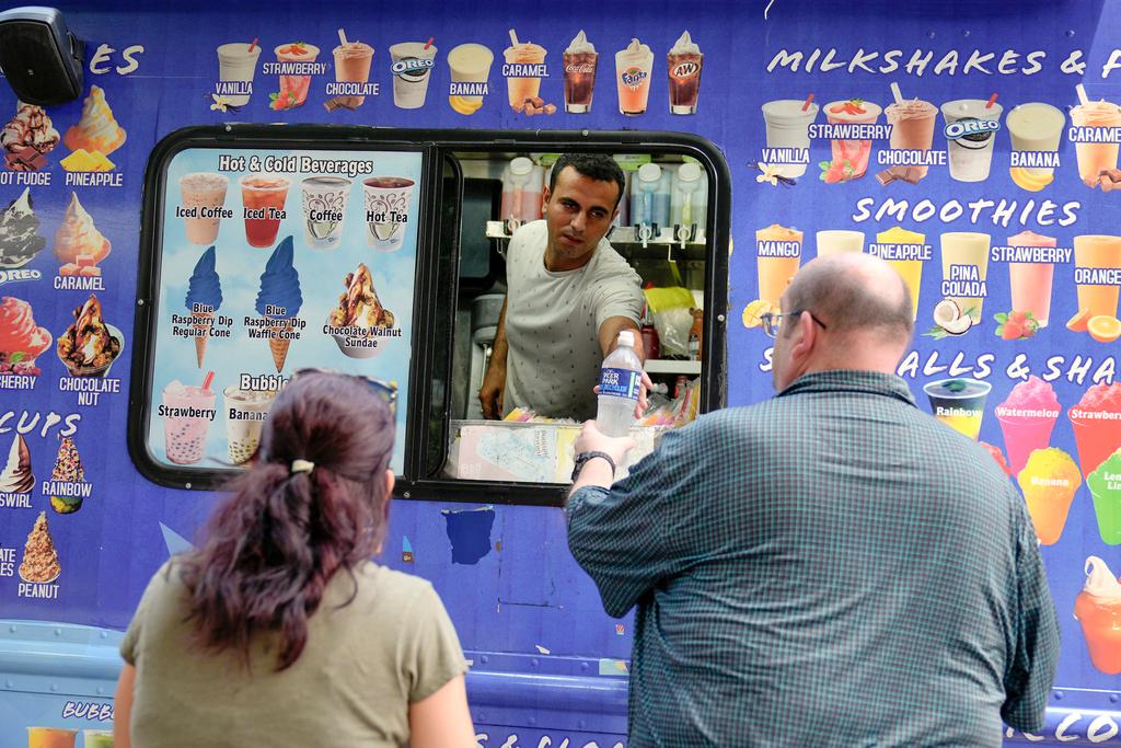 esam Horni, center, sells water on the National Mall near the U.S. Capitol