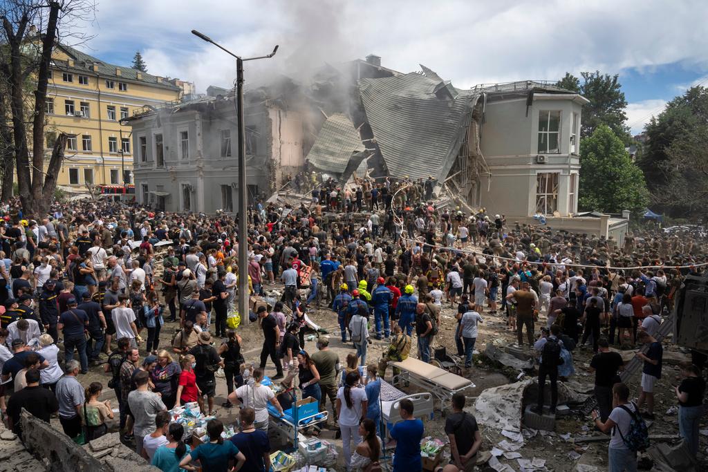 Rescuers and volunteers clean up the rubble and search victims after Russian missile hit the country's main children hospital Okhmadit during massive missile attack 