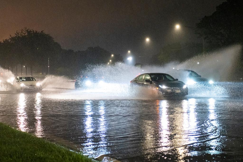 Vehicles make their way through a flooded section of DuSable Lake Shore Drive after a second severe storm raged through Chicago