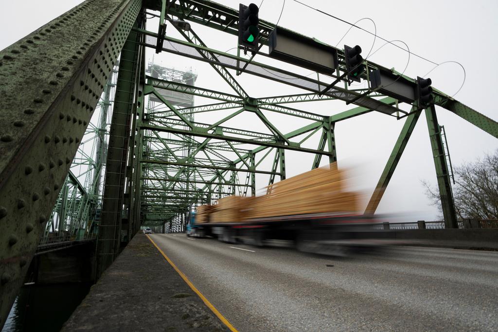 A logging truck drives on the Interstate 5 bridge that spans the Columbia River and connects Portland, Ore., with southwest Washington state, Feb. 13, 2024.