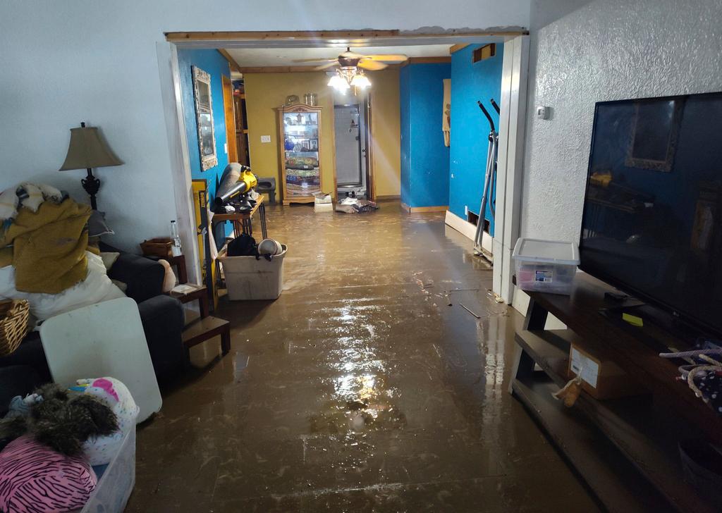 Water and mud coat the floor of Jami Lane's home in Nashville, Ill.