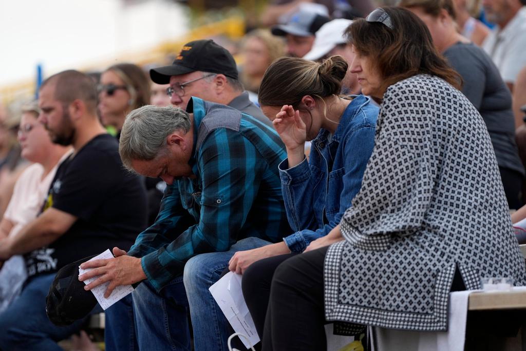 People bow their heads during a vigil for Corey Comperatore, the former fire chief shot and killed at a weekend rally for former President Donald Trump