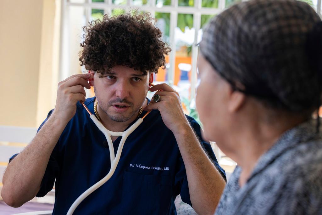Dr. Pedro Juan Vázquez, better known by his stage name PJ Sin Suela, attends to a patient in Loiza, Puerto Rico