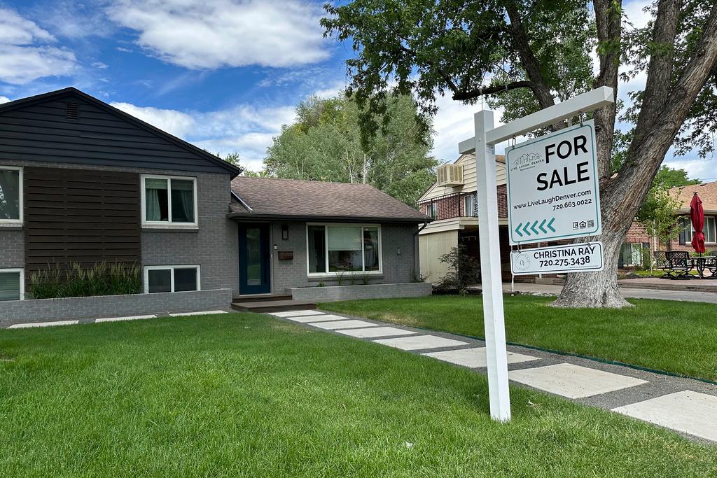 or sale sign stands outside a single-family home in Englewood, Colo