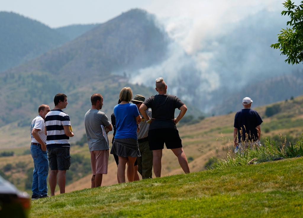 Residents at a roadblock to watch as a wildfire burns in the mountains near the Ken Caryl Ranch development southwest of Littleton, Colo.