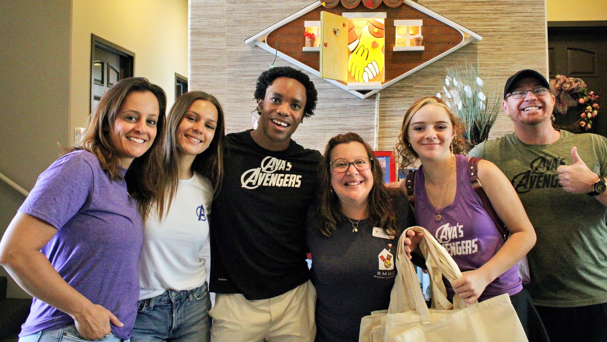 six people, smiling in a lobby