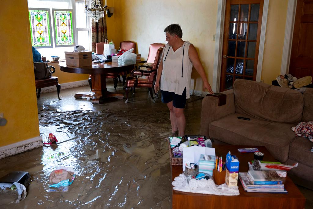 Ann Farkas walks in her flood-damaged home in Canisteo, N.Y.