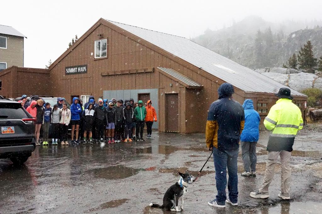 Group of cross country athletes, who had traveled from Davis, Calif., huddle after their practice was canceled due to wet and snowy conditions Saturday, Aug. 24, 2024, in Donner Summit, Calif. 