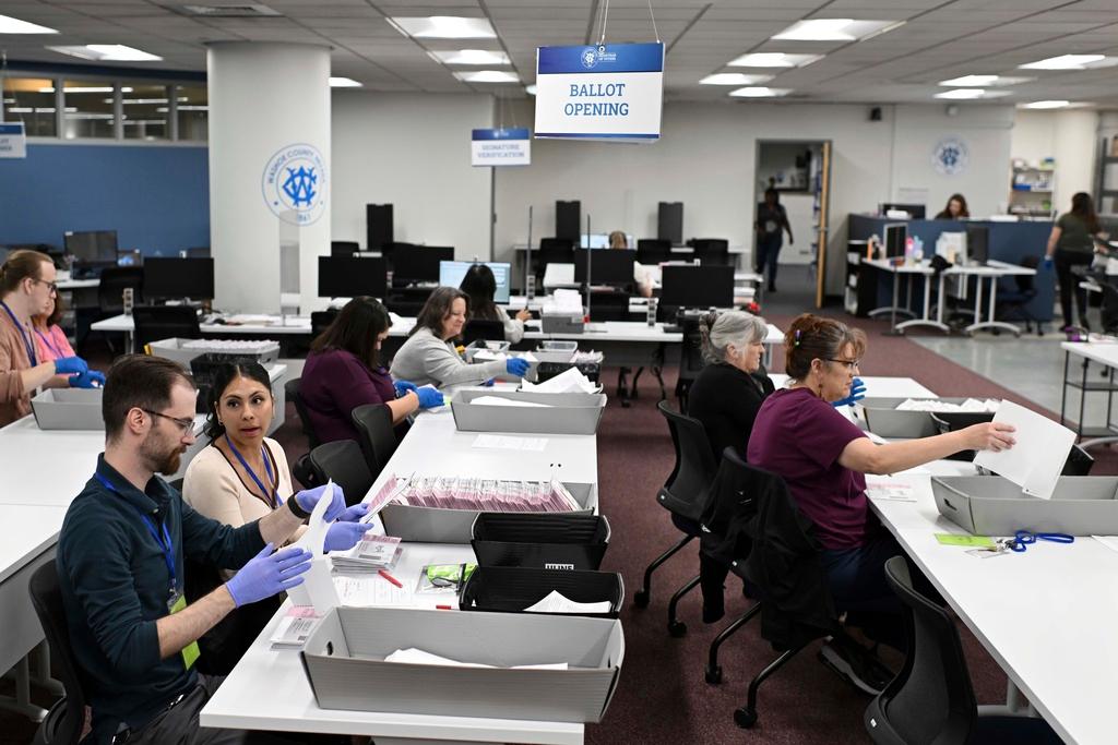 Employees open ballots in the mail ballot processing room 