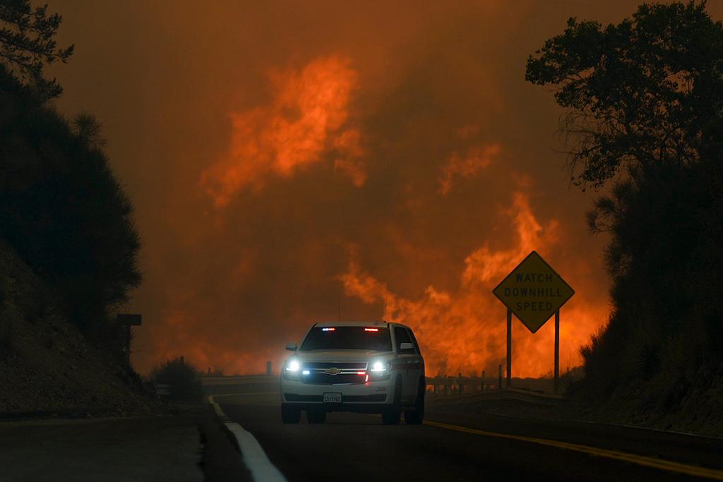 The 'Line Fire' jumps highway 330 as an emergency vehicle is driven past 