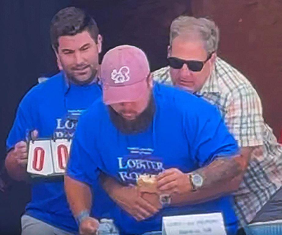 New Hampshire Gov. Chris Sununu uses the Heimlich maneuver on contestant Christian Moreno who is choking at a lobster roll eating contest