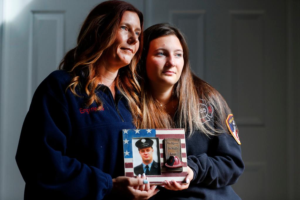 Pamela Yarosz and her daughter Capri are shown with a photo of New York firefighter Christopher Michael Mozzillo 