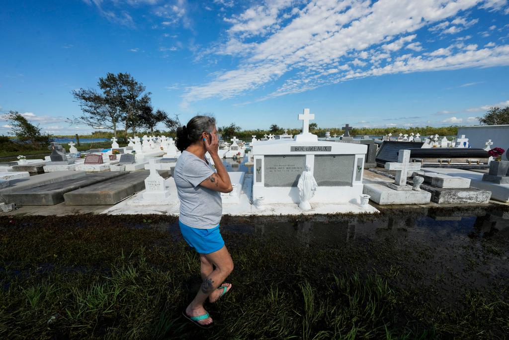 Lori-Ann Bergeron checks on the graves of her sister and mother to see that they were not disturbed by flooding, in the aftermath of Hurricane Francine, in Dulac, La., Thursday, Sept. 12, 2024. 