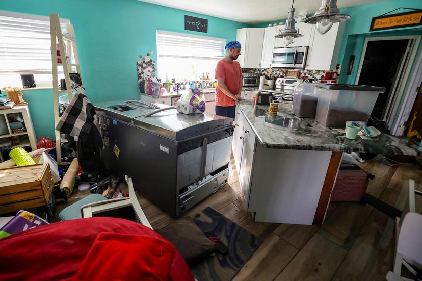 Bradley Tennant looks through his house flooded with water from Hurricane Helene in the Shore Acres neighborhood in St. Petersburg, Fla.