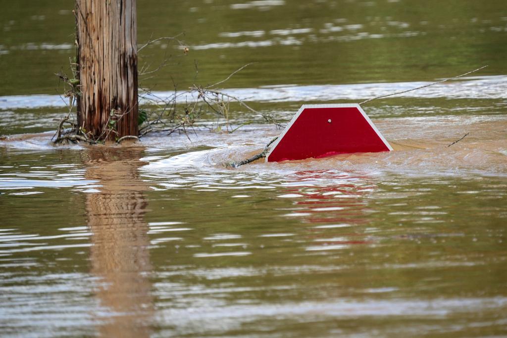 A stop sign can be barely seen above a flooded parking lot after torrential rain from Hurricane Helene caused severe flooding in Morganton, N.C. 