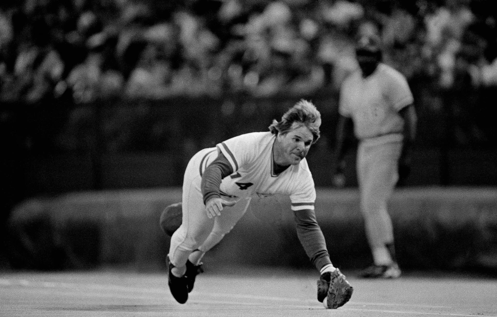 Baseball player in mid-air trying to catch a ball