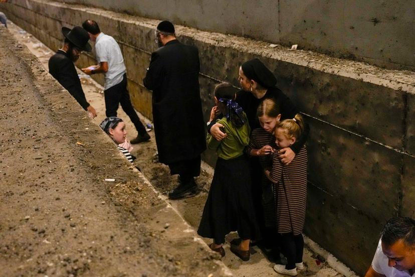 People take cover on the side of the road as a siren sounds a warning of incoming missiles fired from Iran on a freeway in Shoresh, between Jerusalem and Tel Aviv 