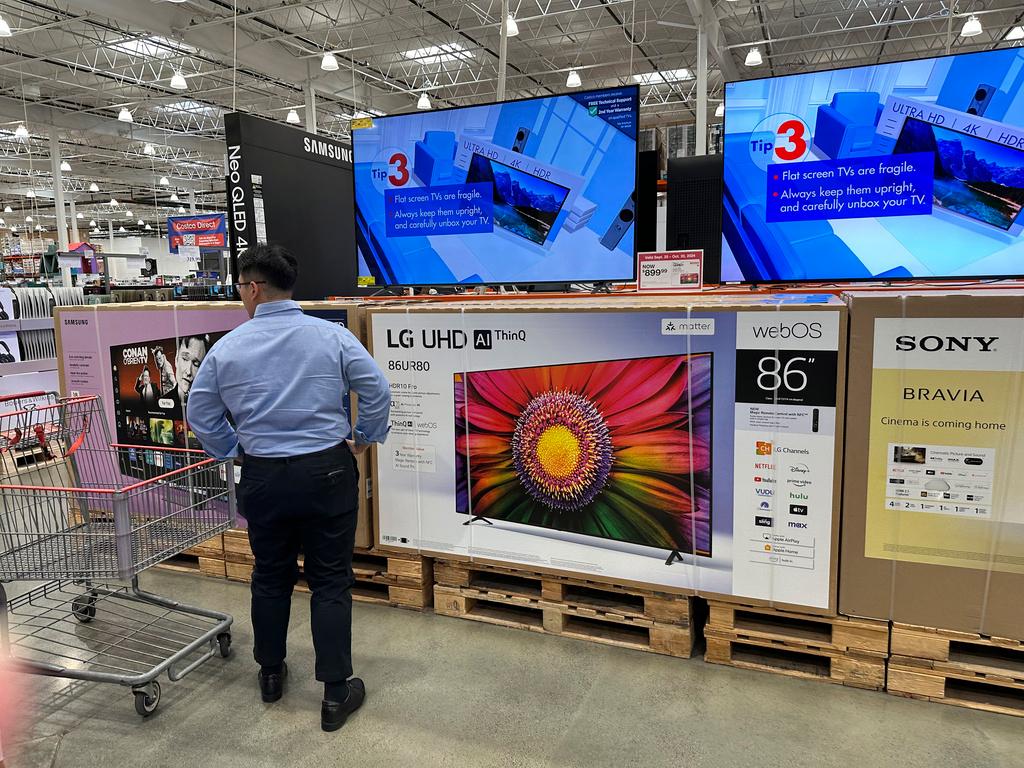 Shopper considers large-screen televisions on display in a Costco warehouse 