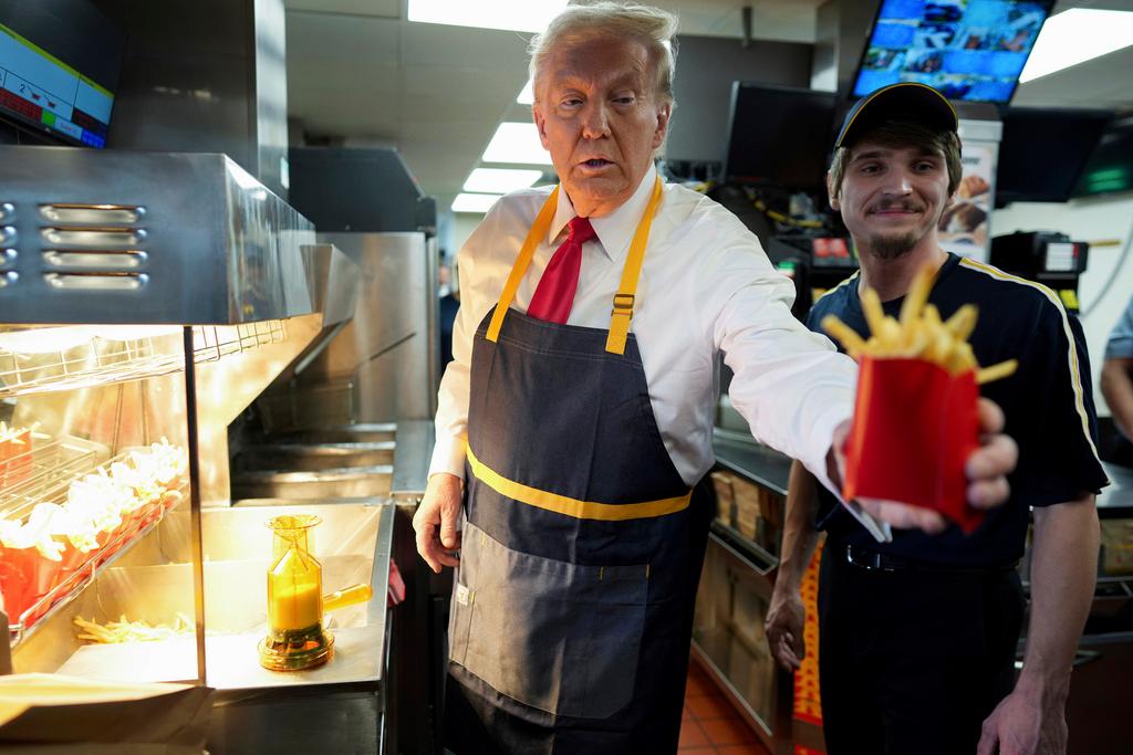 An employee showed Trump how to dunk baskets of fries in oil, salt the fries and put them into boxes using a scoop.