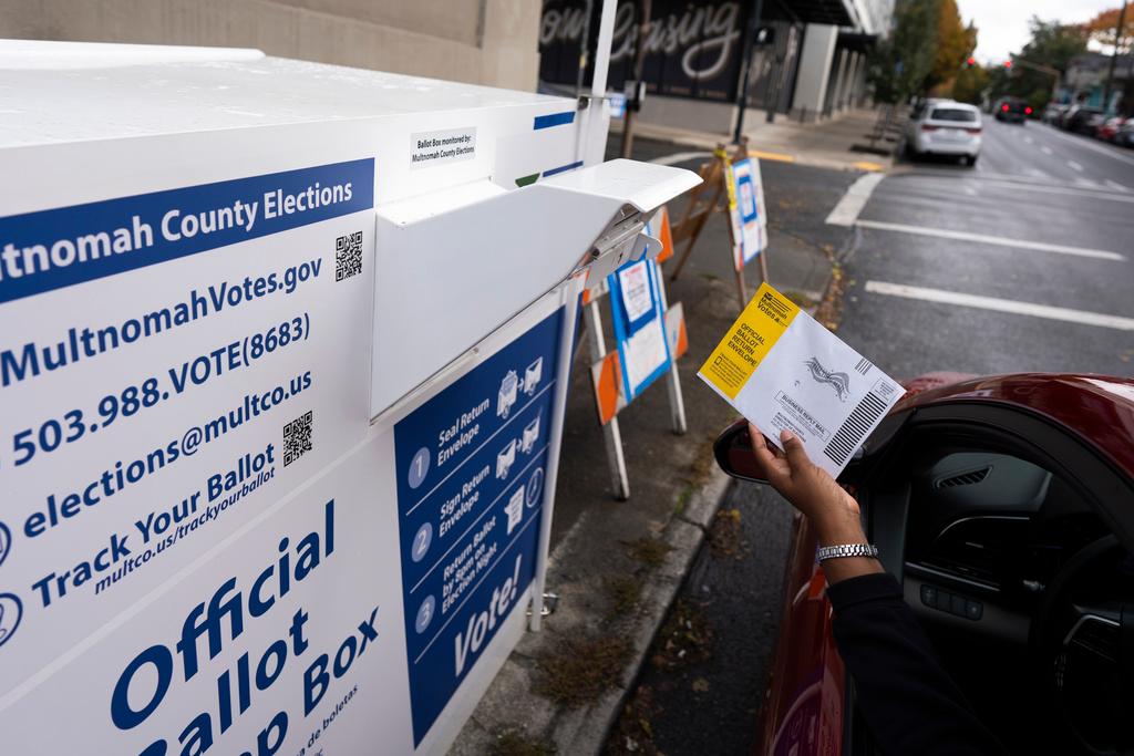 Voter drops off a ballot for the 2024 election in a newly installed drop box at the Multnomah County Elections Division office in Portland, Ore.