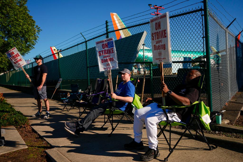 FILE - Boeing 737 Max aircrafts are seen behind fences as striking Boeing workers picket on Sept. 24, 2024, next to the company's facilities in Renton, Wash. 