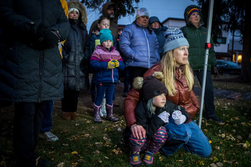 Rae Smith, 6, and her mother Leigh Reagan Smith listen to speakers at a candlelight vigil for grizzly bear No. 399 in Jackson, Wyo.