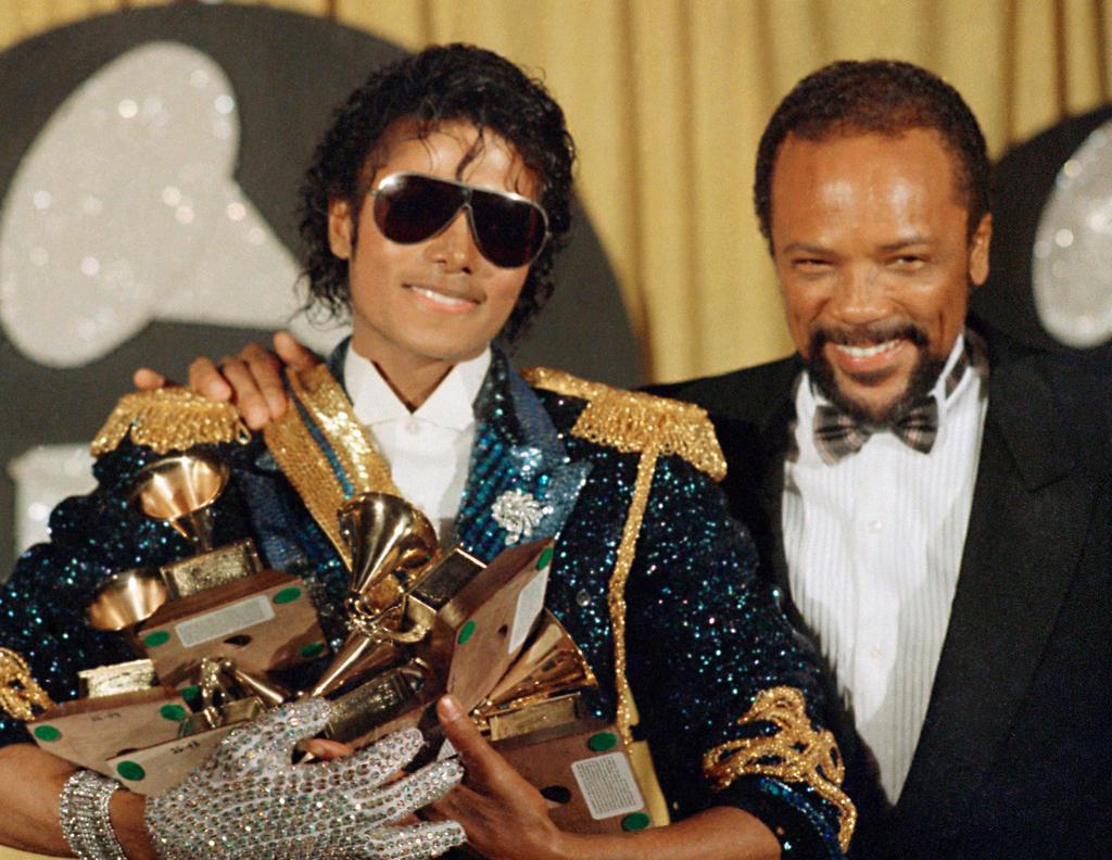 Michael Jackson, left, holds eight awards as he poses with Quincy Jones at the Grammy Awards in Los Angeles, Feb. 28, 1984. Quincy Jones died at age 91. 