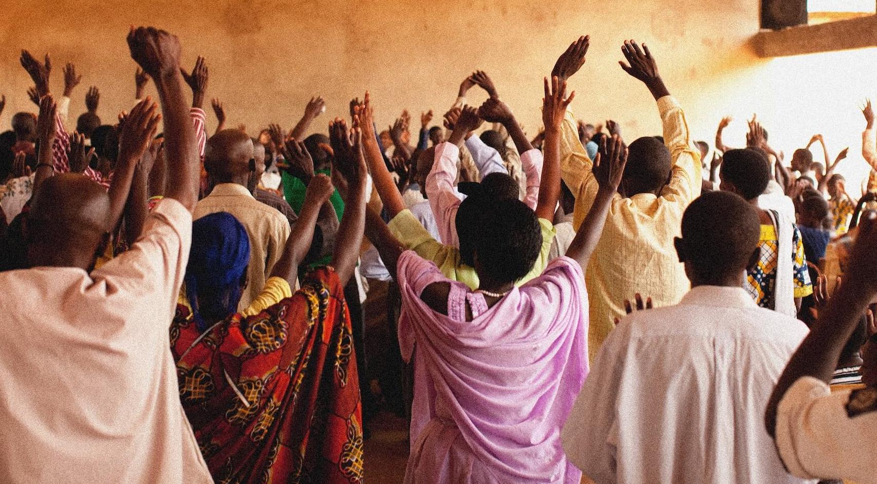 People worshipping in Africa in a big, stucco building