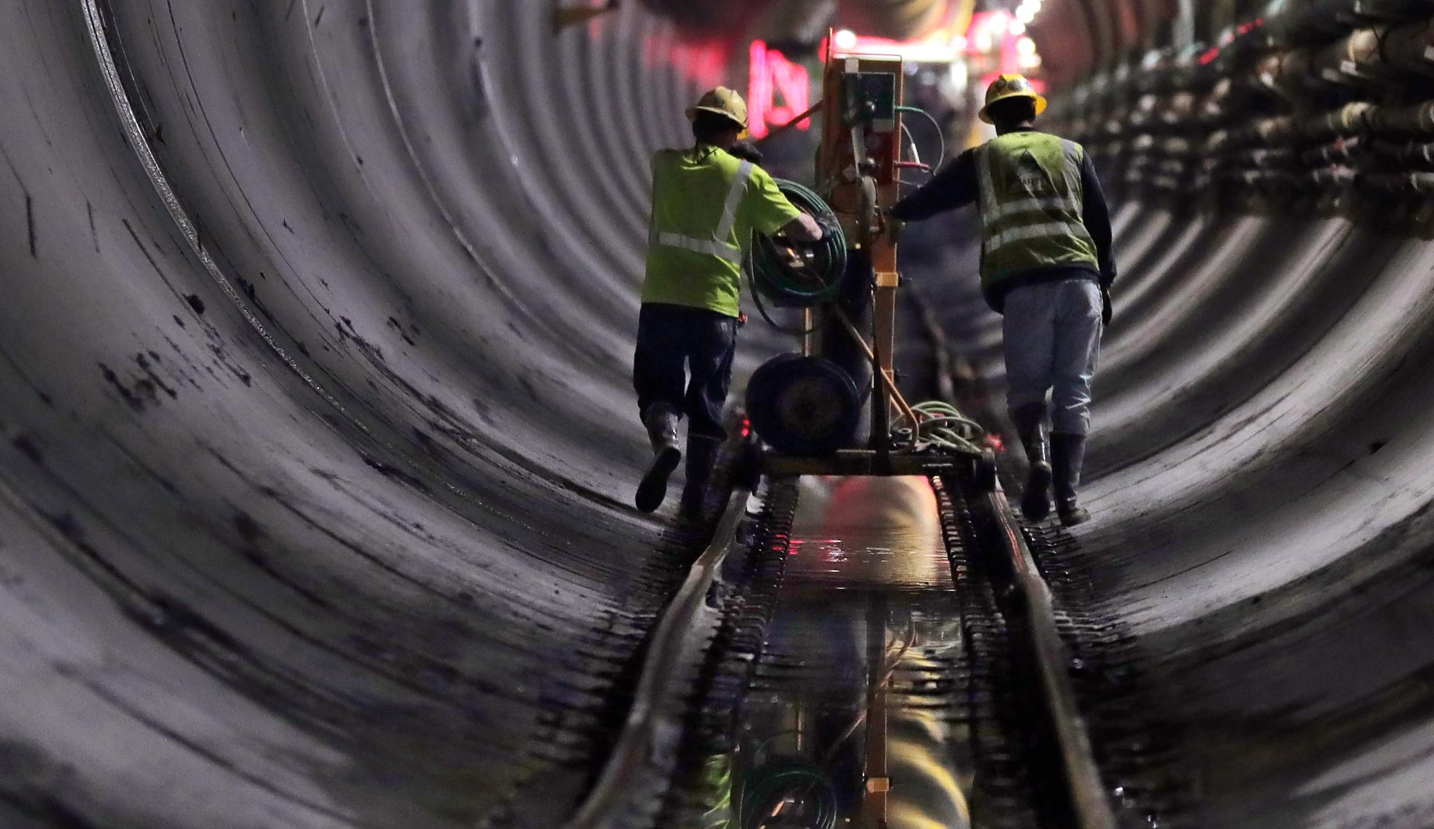 Two men rolling something in an aquaduct