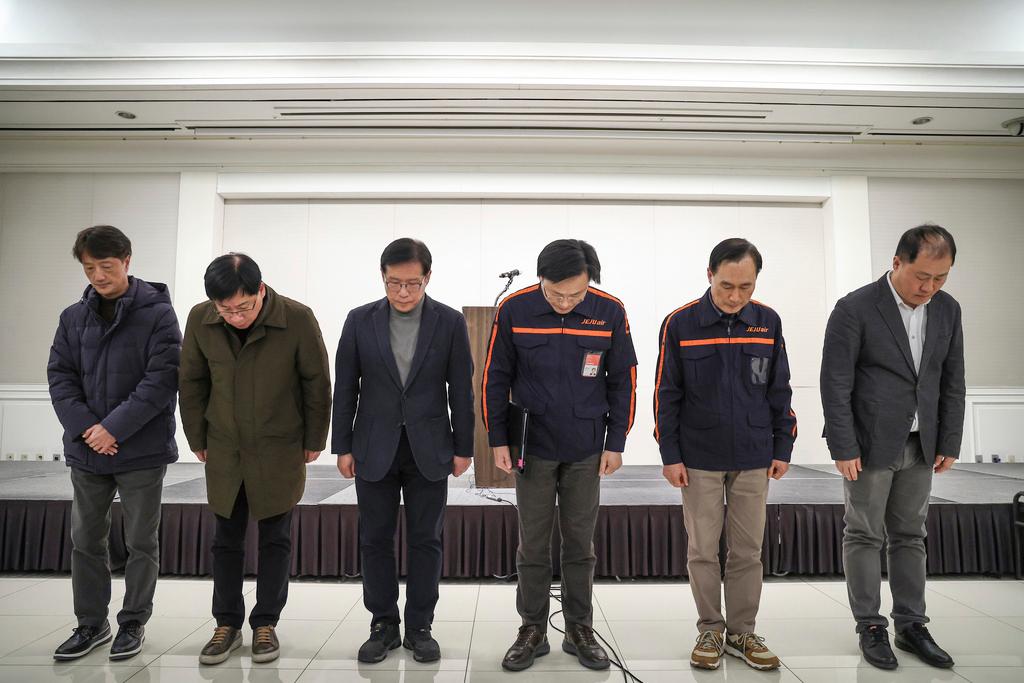 Jeju Air CEO Kim E-bae, fourth from left, and other executive members bow in apology ahead of a briefing in Seoul, South Korea