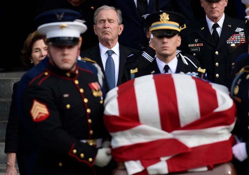 Former President George W. Bush and former first lady Laura Bush, left, follow the casket of former President George H.W. Bush, carried out following a State Funeral at the National Cathedral in Washington, Dec. 5, 2018.