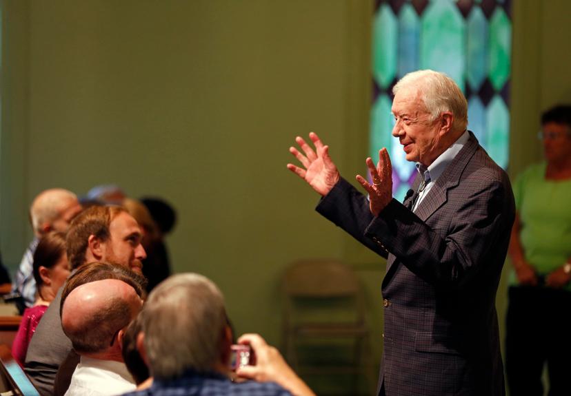 Former President Jimmy Carter welcomes visitors to Maranatha Baptist Church before teaching Sunday school in Plains, Ga.