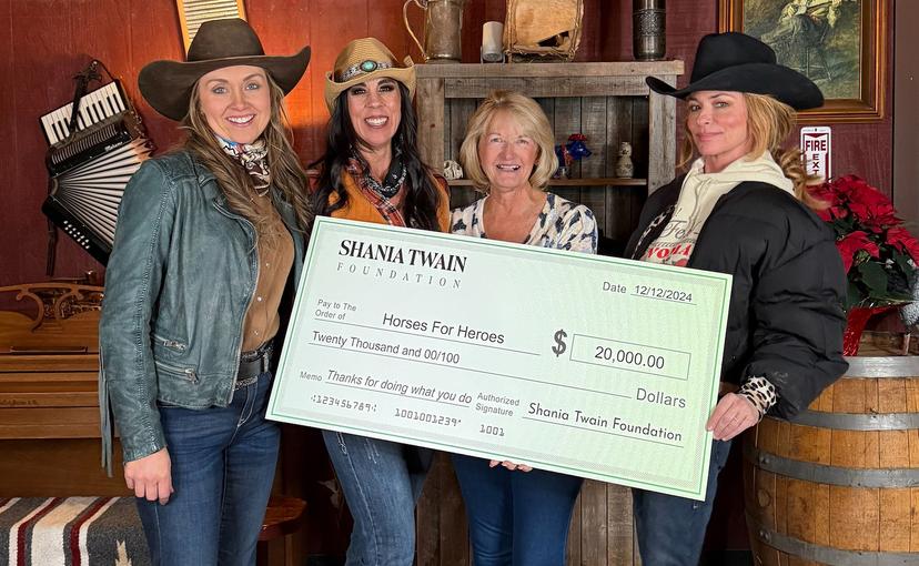 Four women holding a check for $20,000 from the Shania Twain Foundation