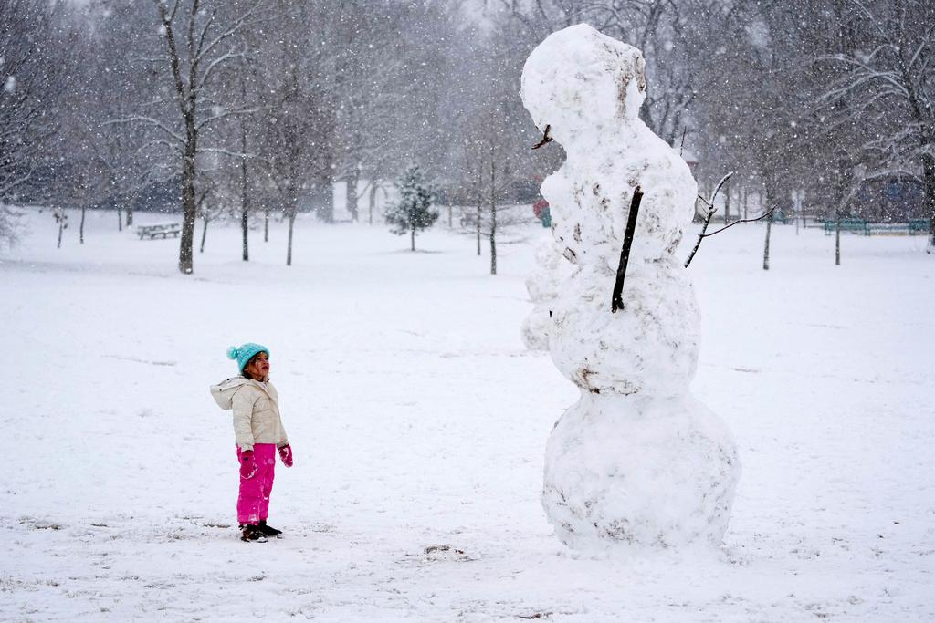 Brooklyn Brye, 4, looks up at giant snowman, in Nashville, Tenn.