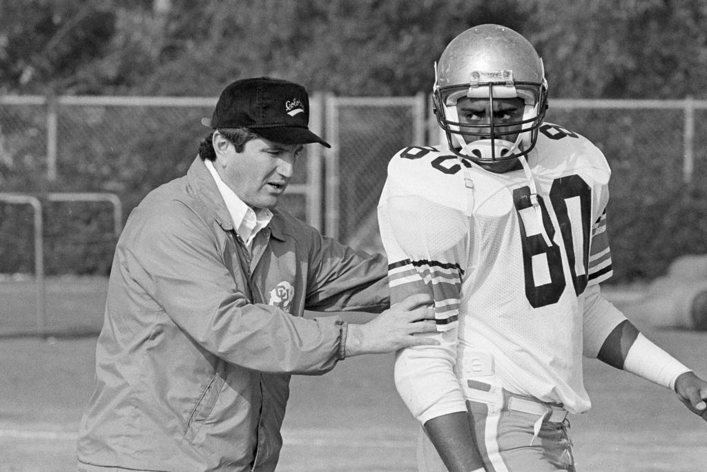 (1985) Colorado University head coach Bill McCartney repositions tight end Jon Embree (80) during practice