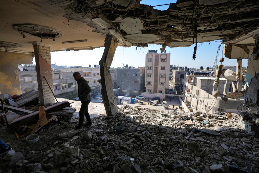 A Palestinian looks at a damaged residential building following an overnight Israeli strike in Deir al-Balah, Gaza Strip, Wednesday, Jan. 8, 2025.