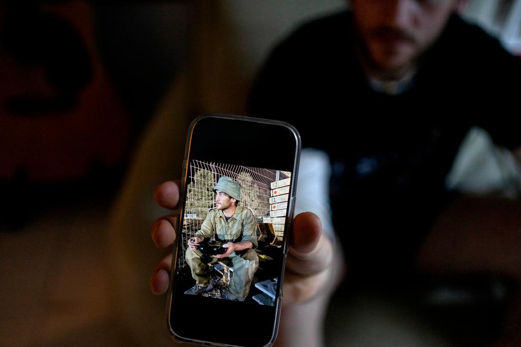 Yotam Vilk shows a photo of himself on the Israel-Gaza border during army reserve duty before he joined a growing number of Israeli soldiers speaking out against the 15-month conflict and refusing to continue fighting