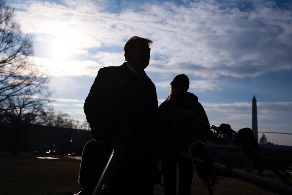 First lady Melania Trump looks on as President Donald Trump speaks with reporters before boarding Marine One on the South Lawn of the White House